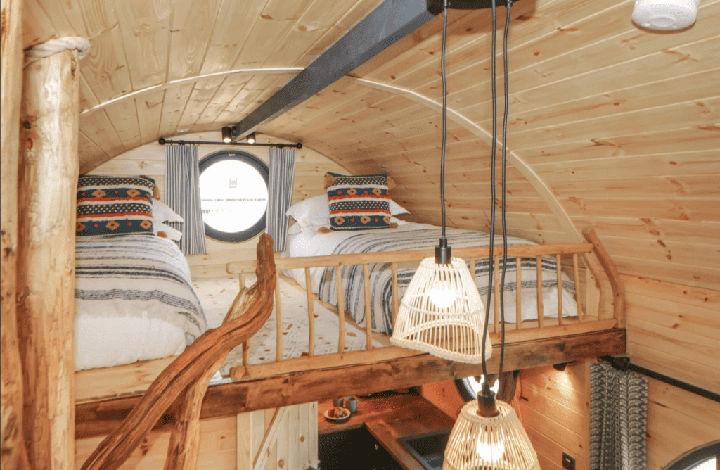 Two single beds under the domed roof of the log cabin