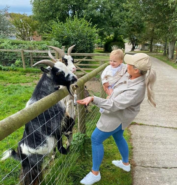 Mother and child feeding hungry goats