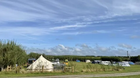 View of tents in fields at Lee Meadow Farm campsite