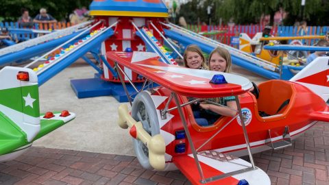 Children say in. the cockpit of a theme park ride plane