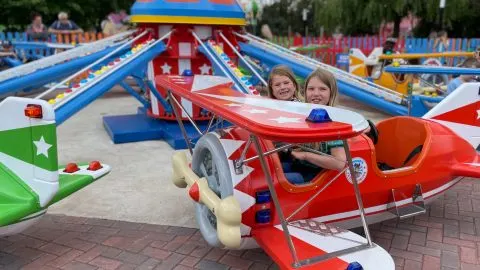 Children say in. the cockpit of a theme park ride plane