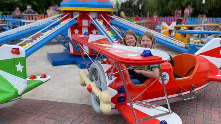 Children say in. the cockpit of a theme park ride plane