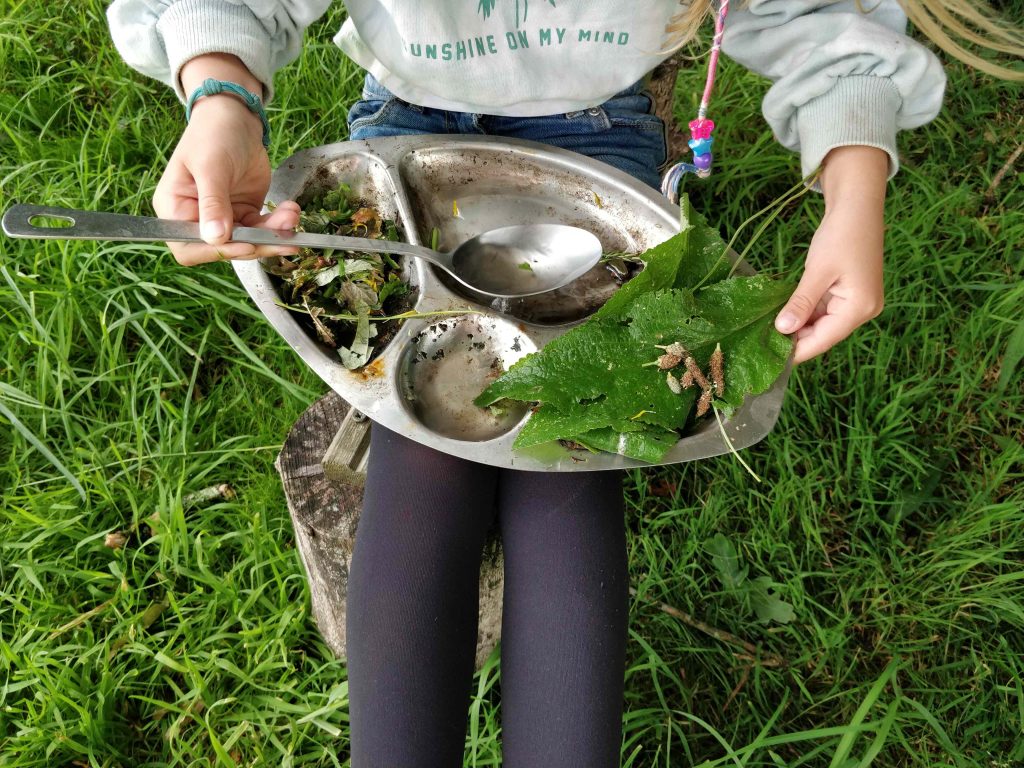 Silver platter with picked leaves on child's knee