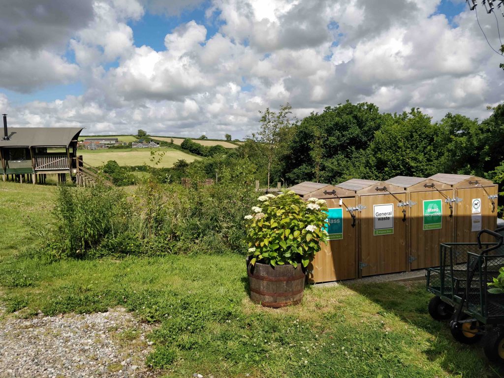 View down glamping field with recycling bins in foreground