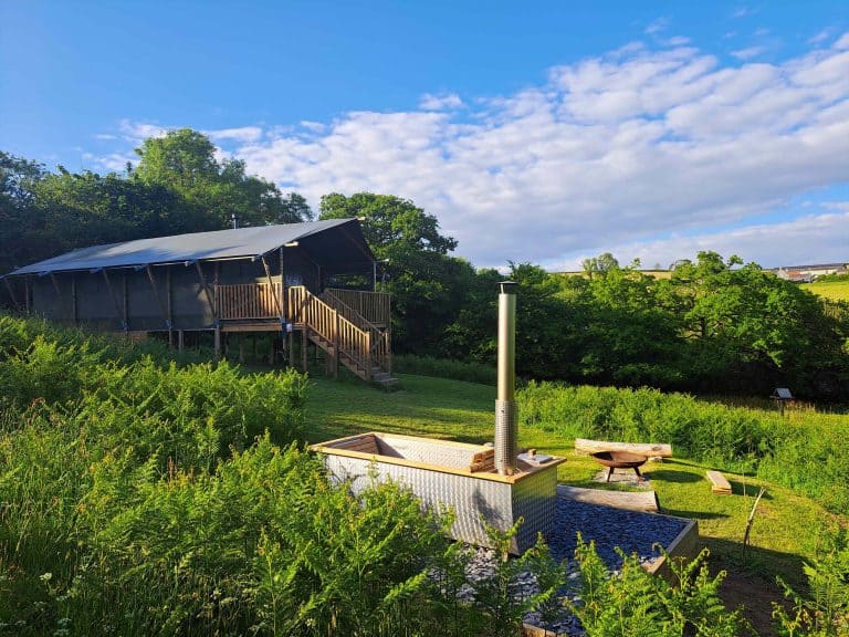 Glamping safari tent and wood fired hot tub in field at Bracenkhill Glamping in Devon