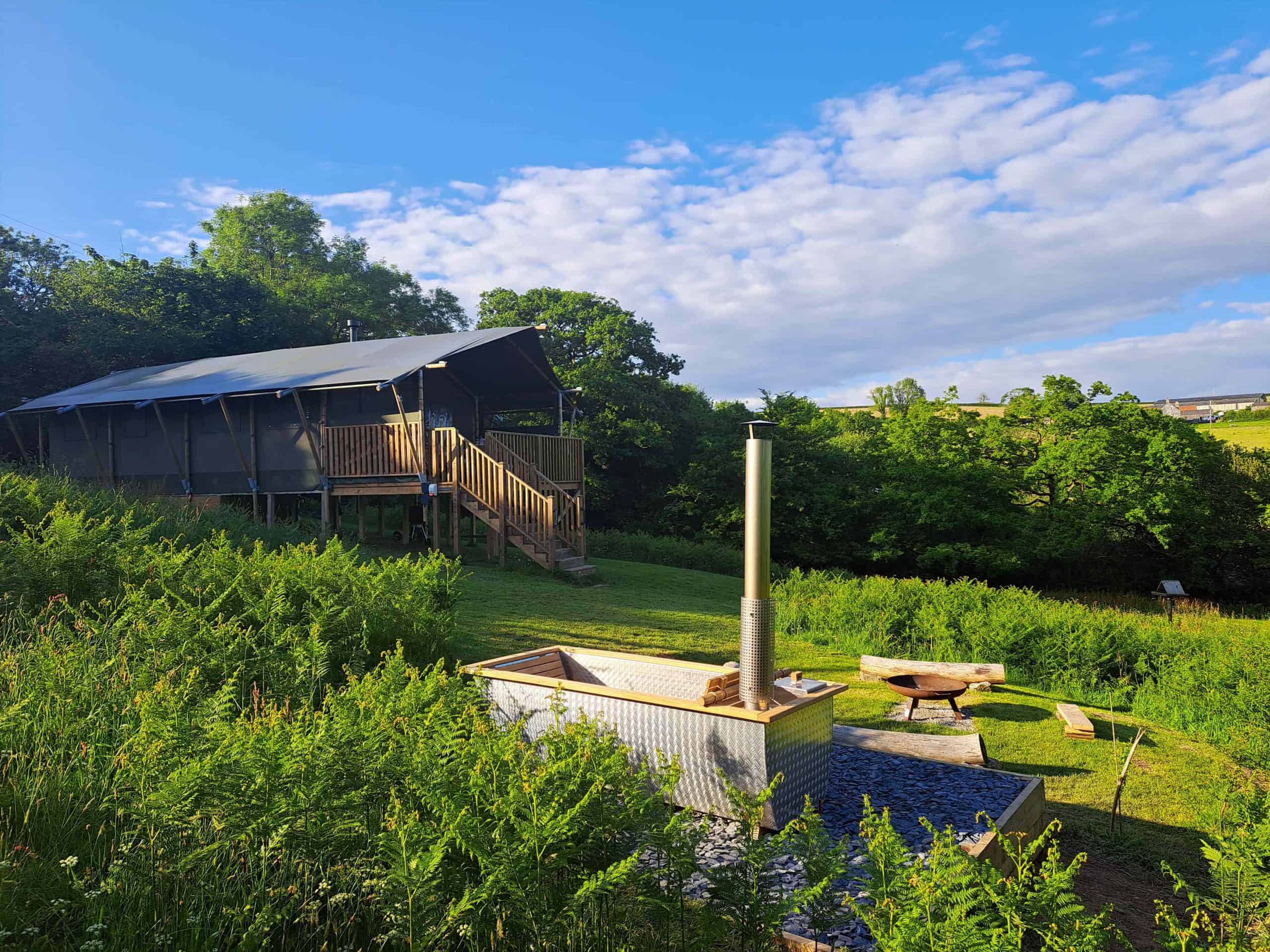 Glamping safari tent and wood fired hot tub in field at Bracenkhill Glamping in Devon