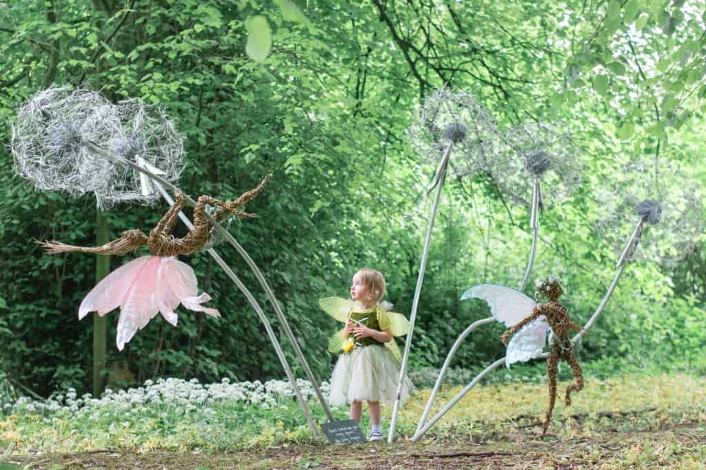 Child looking at fairy sculptures in The Garden House gardens
