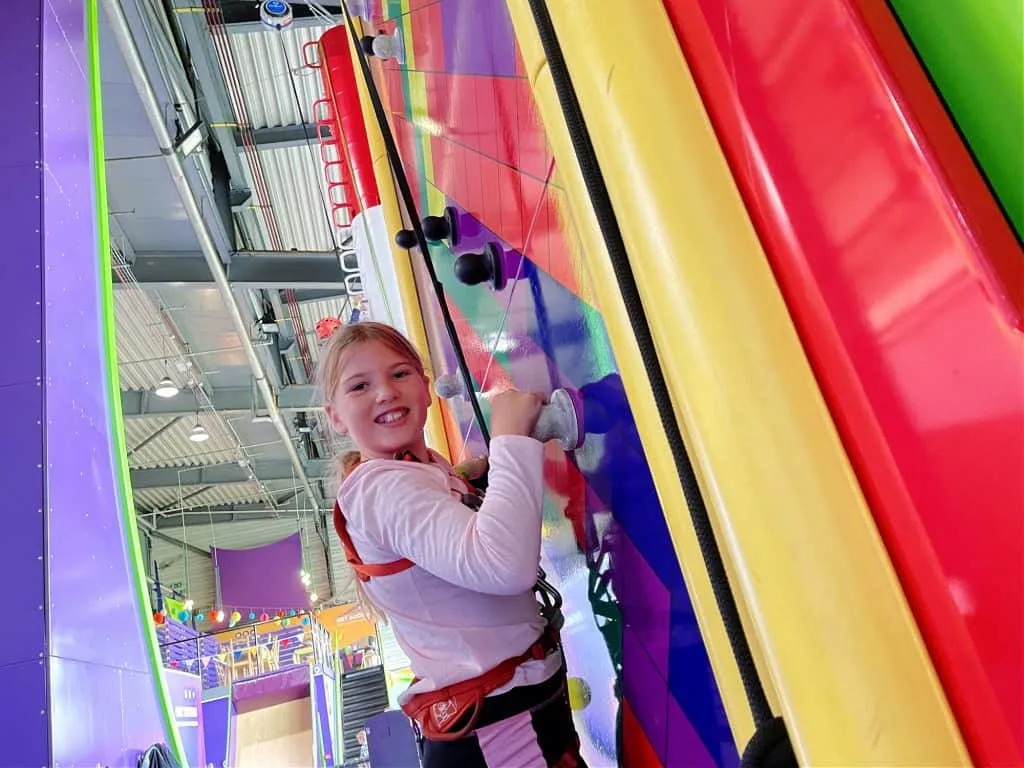 Girl on colourful climbing wall