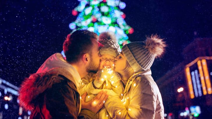 Happy family with lights city background and snow at night