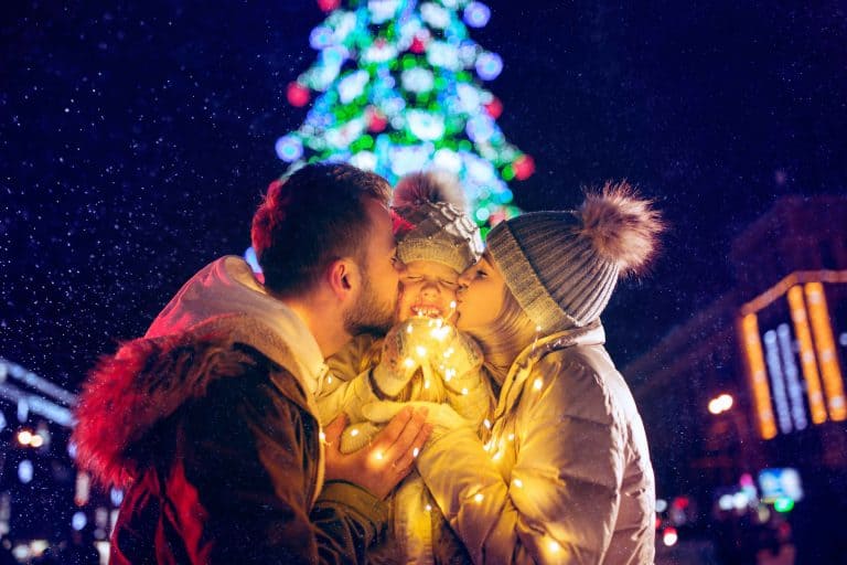 Happy family with lights city background and snow at night