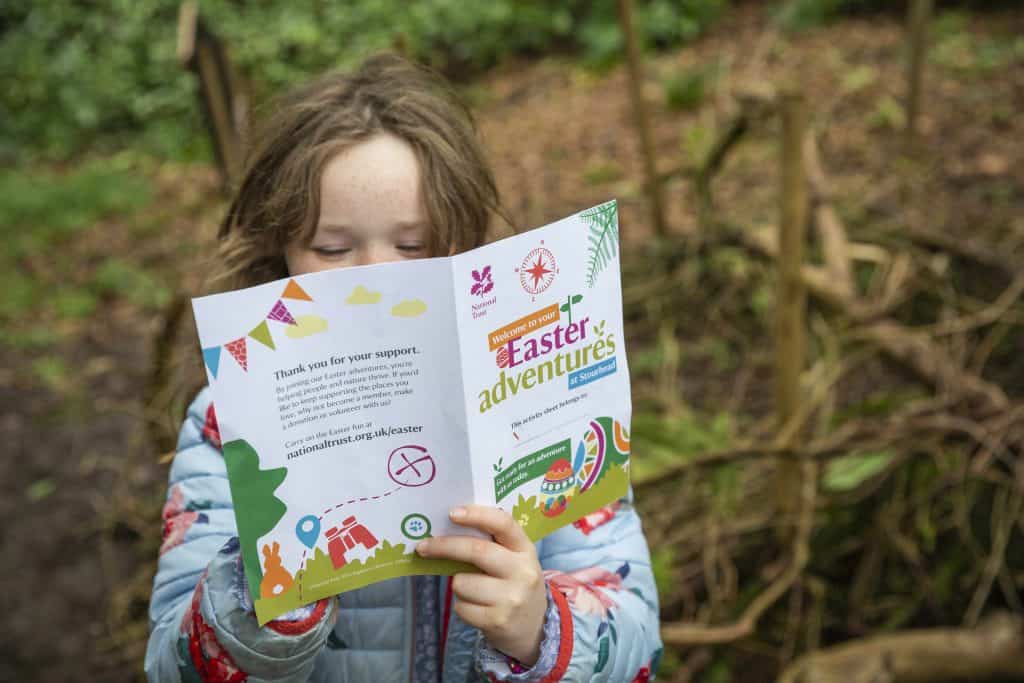 A girl reading her Easter trail activity sheet 
