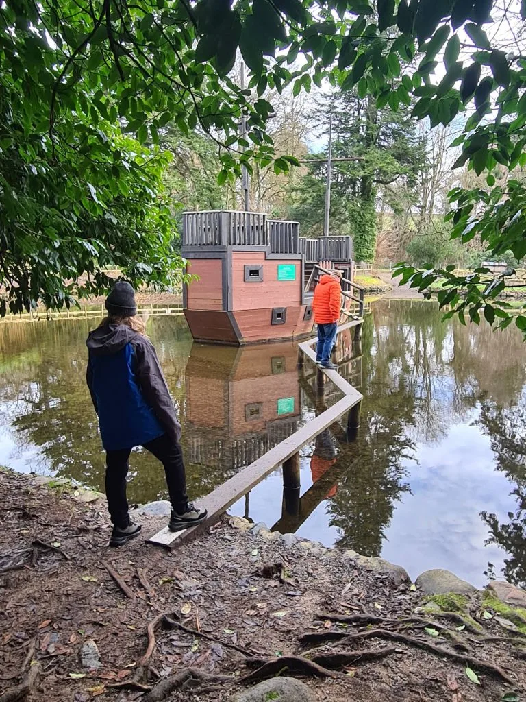 Family walking across narrow plank bridge to pirate ship play feature