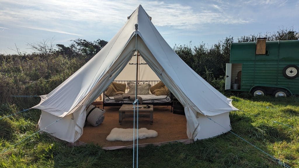 A bell tent with soft furnishings inside