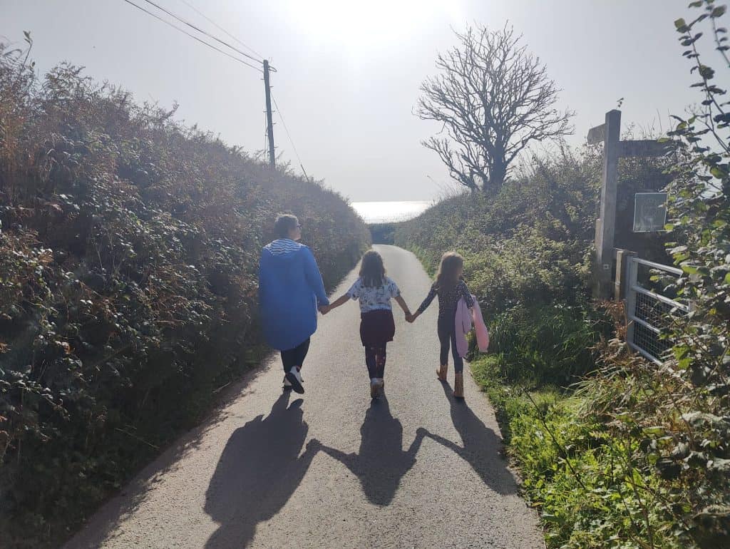 Stacey walking down a country lane with her two children