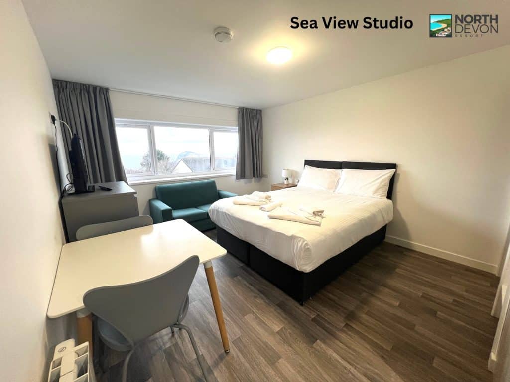 Bed and dining table in a sea view studio ay North Devon Resort