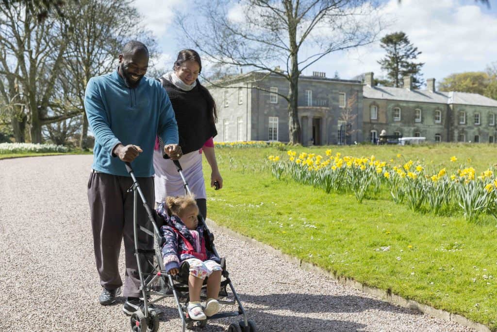 A family exploring the garden in spring at Arlington Court, Devon.