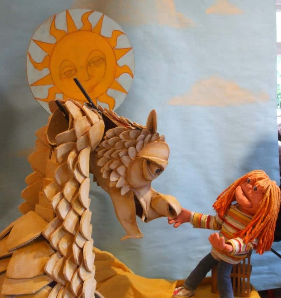 A dragon puppet and puppet child make of paper and material 