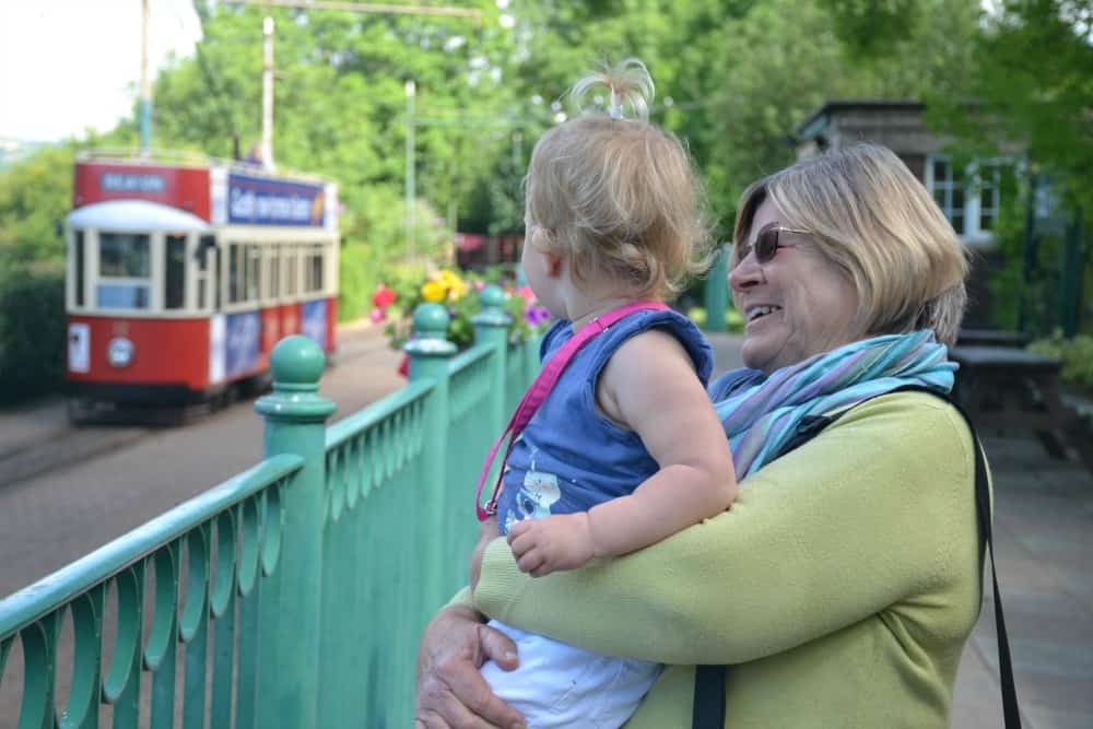 Grandmother and baby looking at a tram at Seaton Tramway