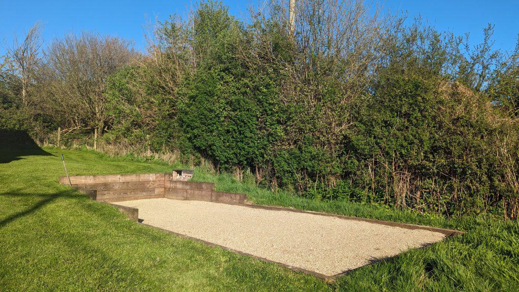 The outdoor boules and skittles area in a field