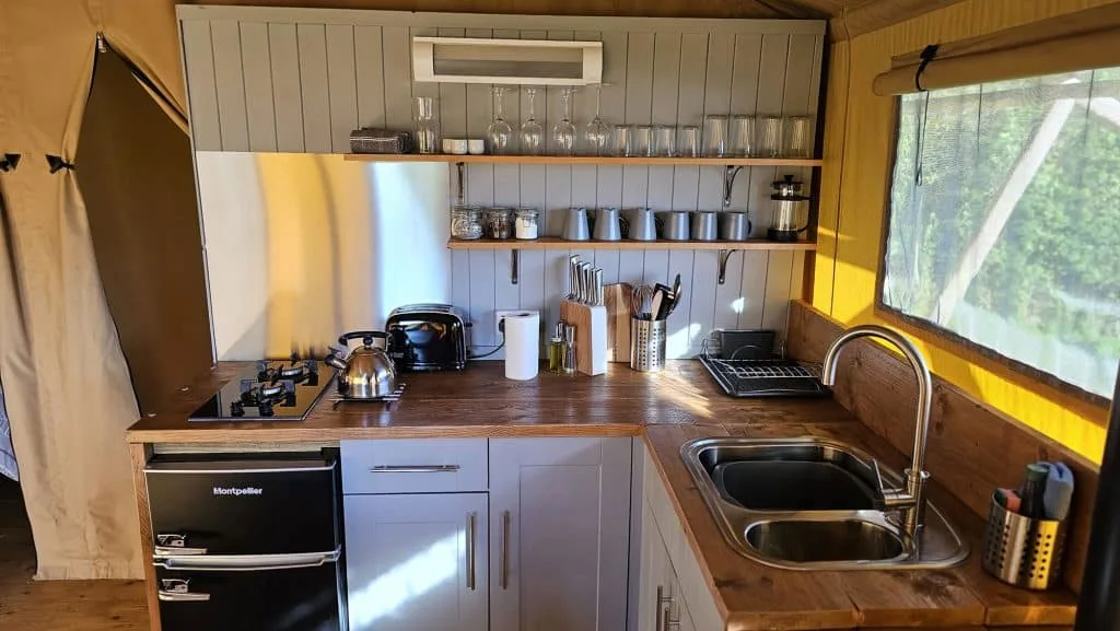 The kitchen inside Stacey's safari tent with all the mod cons - and oven, sink utensils and shelving