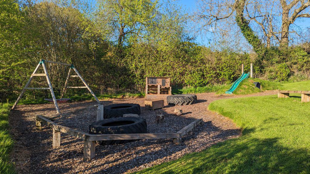 Play area with wooden play equipment at Valleyside Escapes glamping site