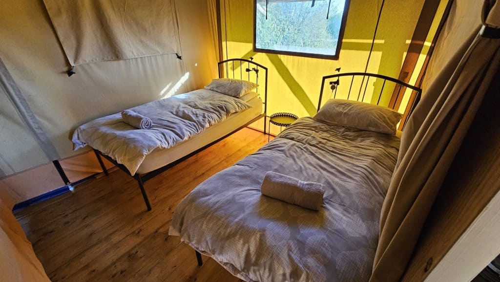 Twin beds inside a bedroom in the glamping tent