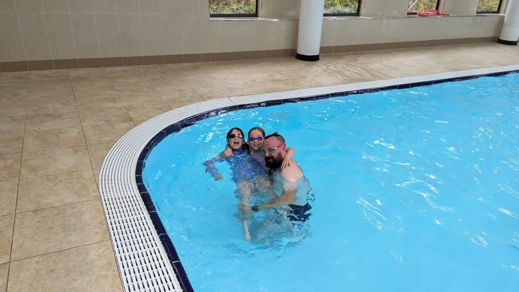 Stacey's husband and children in the indoor pool at Stacey's children on the outdoor playground at Cofton Holiday Park in South Devon