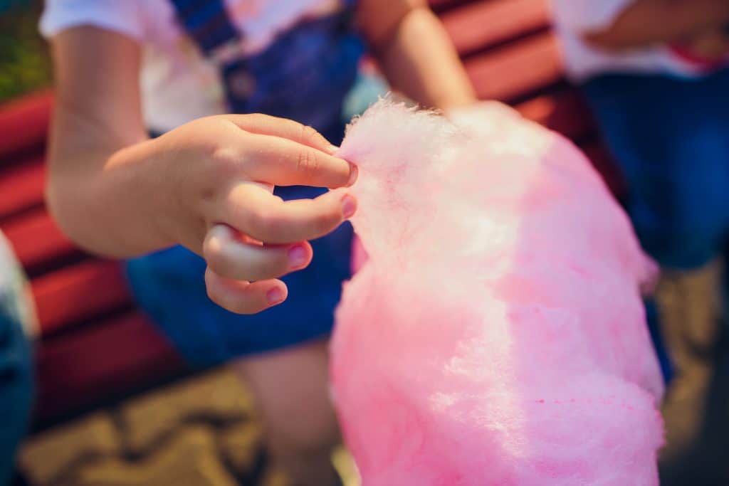 The hands of girl holding pink cotton candy