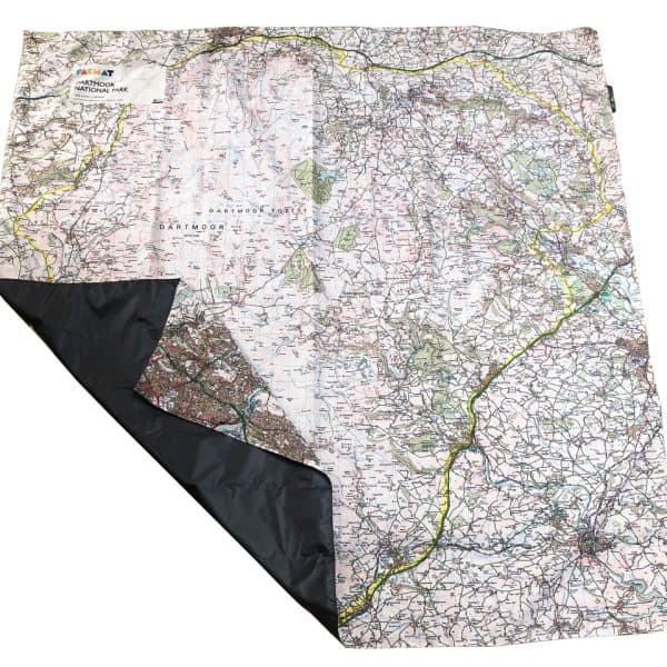 The OS Dartmoor PACMAT picnic blanket laid out on the floor with one side folded over to show the back