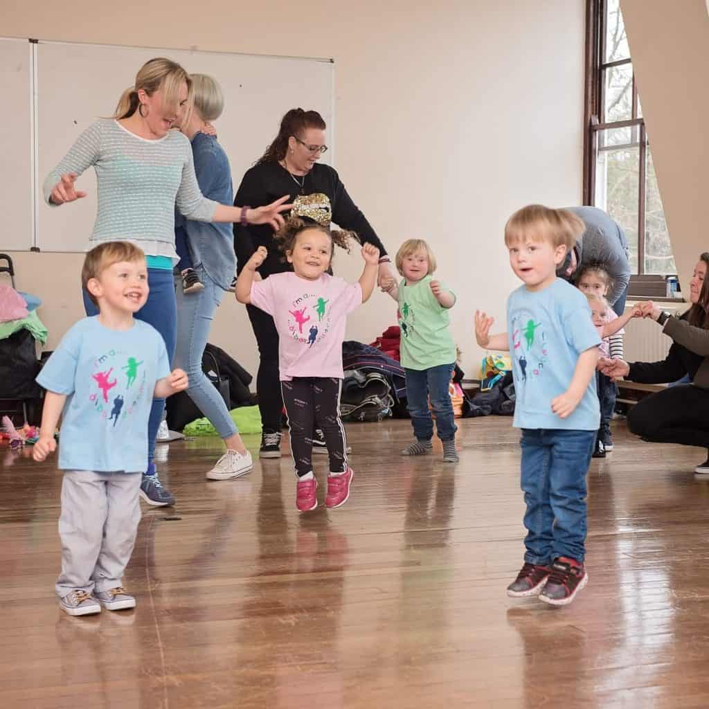 Toddlers and parents dance around