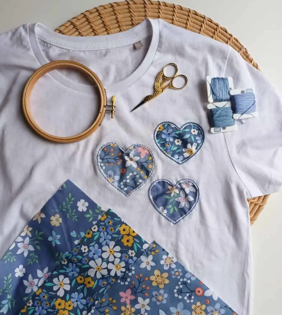 Hearts embroidered onto a white t-shirt with tools laid on top