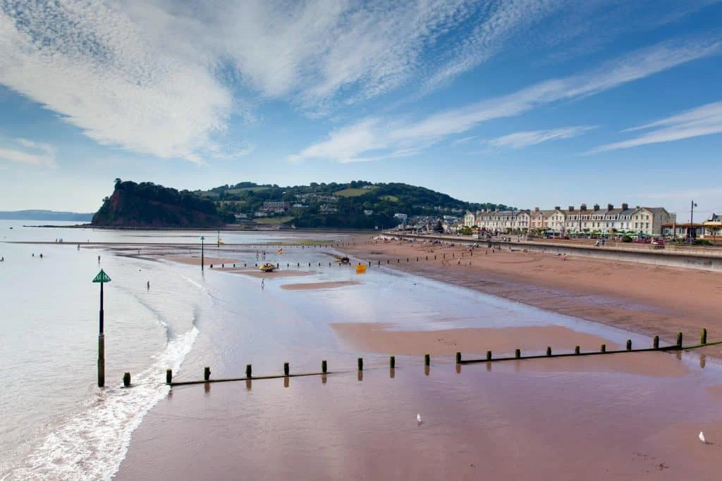 Orange sand and wooden  groynes on the beach at Teignmouth in South Devon
