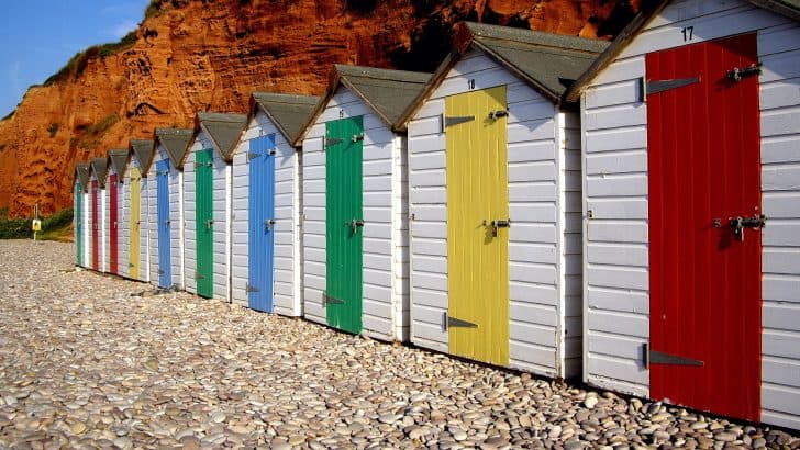 Colourful beach huts along the red cliffs at Budleigh Salterton beach in East Devon
