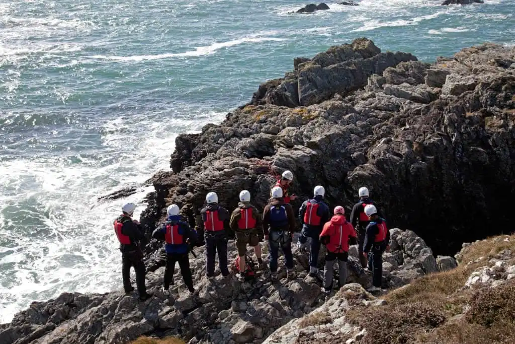 Group of people coasteering on a rocky outcrop