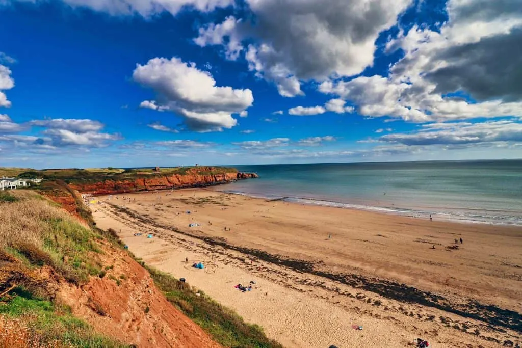 Sandy Bay beach just outside of Exmouth. The cliffs surrounding it are red and you can see the Devon Cliffs Holiday Park just to the left