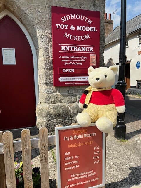 The outside of Sidmouth Toy Museum which is housed in a former chapel. A vintage teddy bear sits on the wall outside