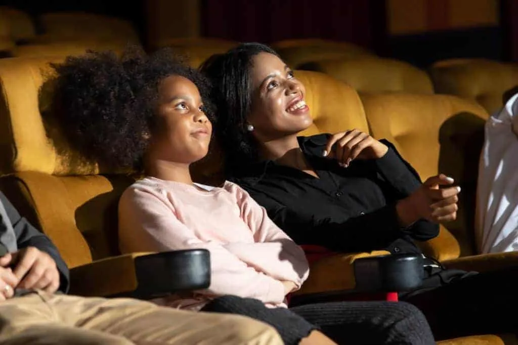 Happy family watching movie in cinema theatre.