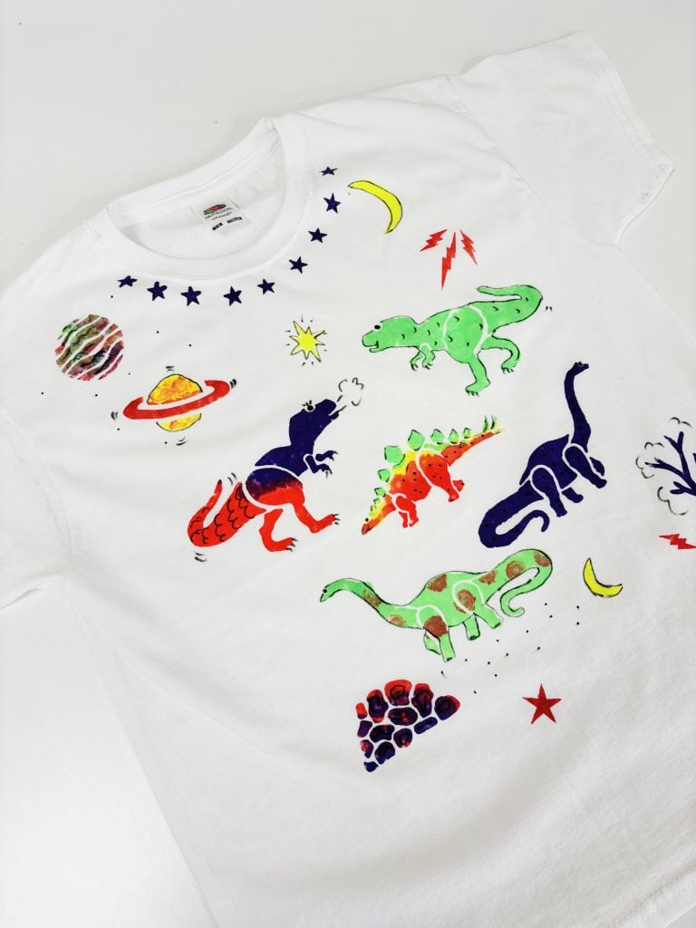 A white T-shirt printed with dinosaur shapes
