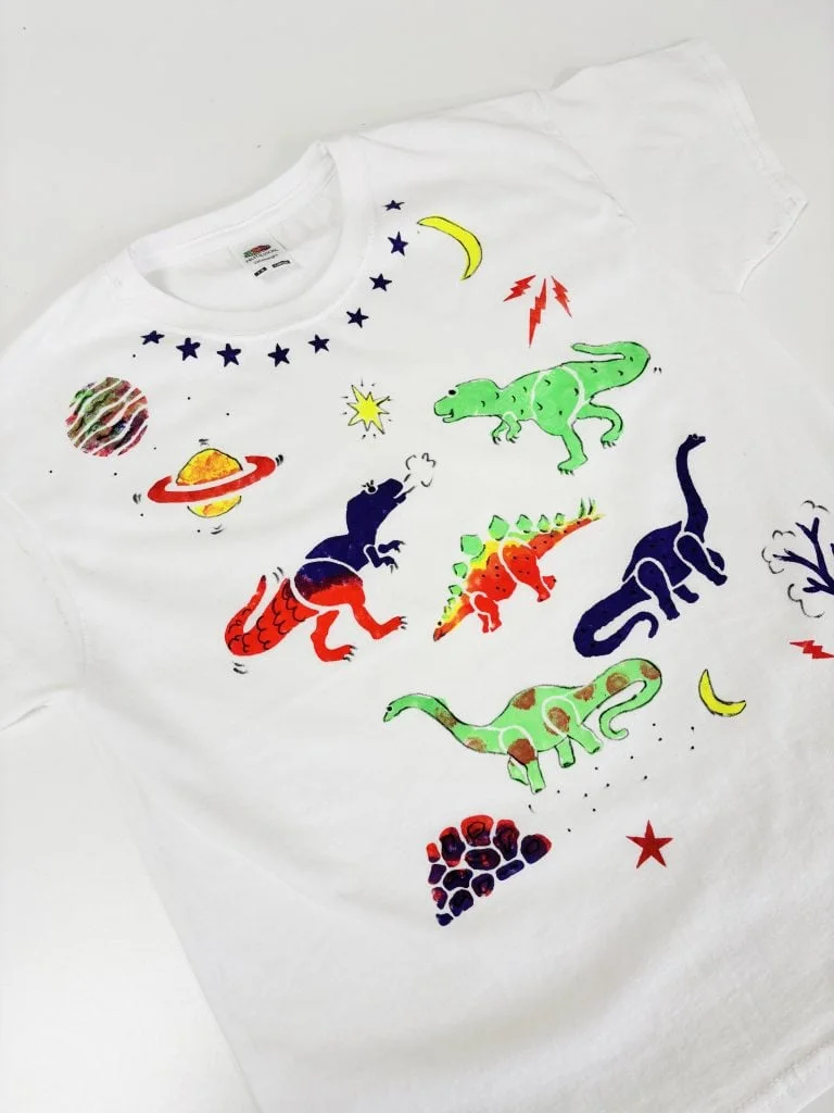 A white T-shirt printed with dinosaur shapes