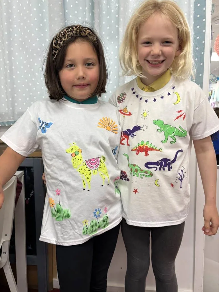 A pair of girls wearing T-shirts they have designed and printed themselves