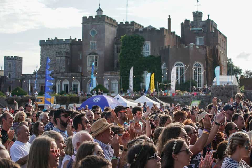 Festival goers gather outside Powderham Castle