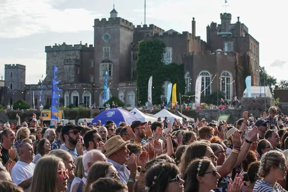 Festival goers gather outside Powderham Castle