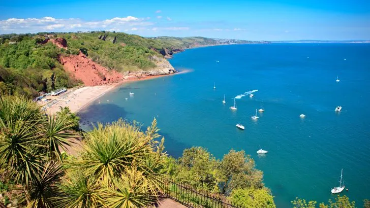 A view of Oddicombe Bay from Babbacombe Downs. It is a summers day and the sea and sky are bright blues