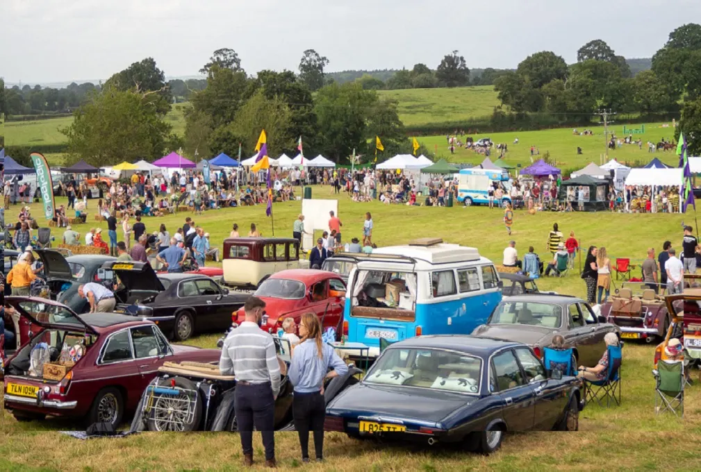 A crowded field of people. cars and stalls at Plymtree Country Fayre