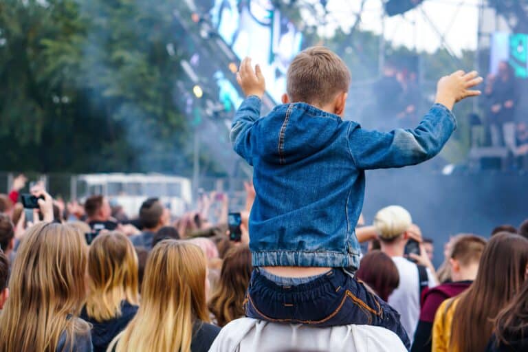 Children sit around the neck at a street concert