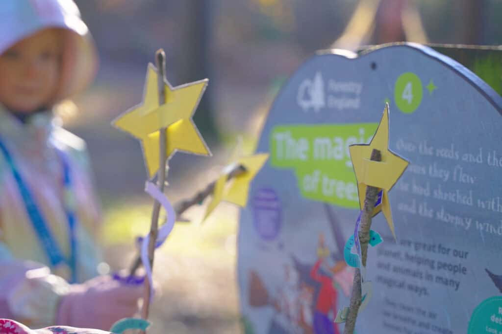 Crafted magic wands held up against a Room on the Broom activity board