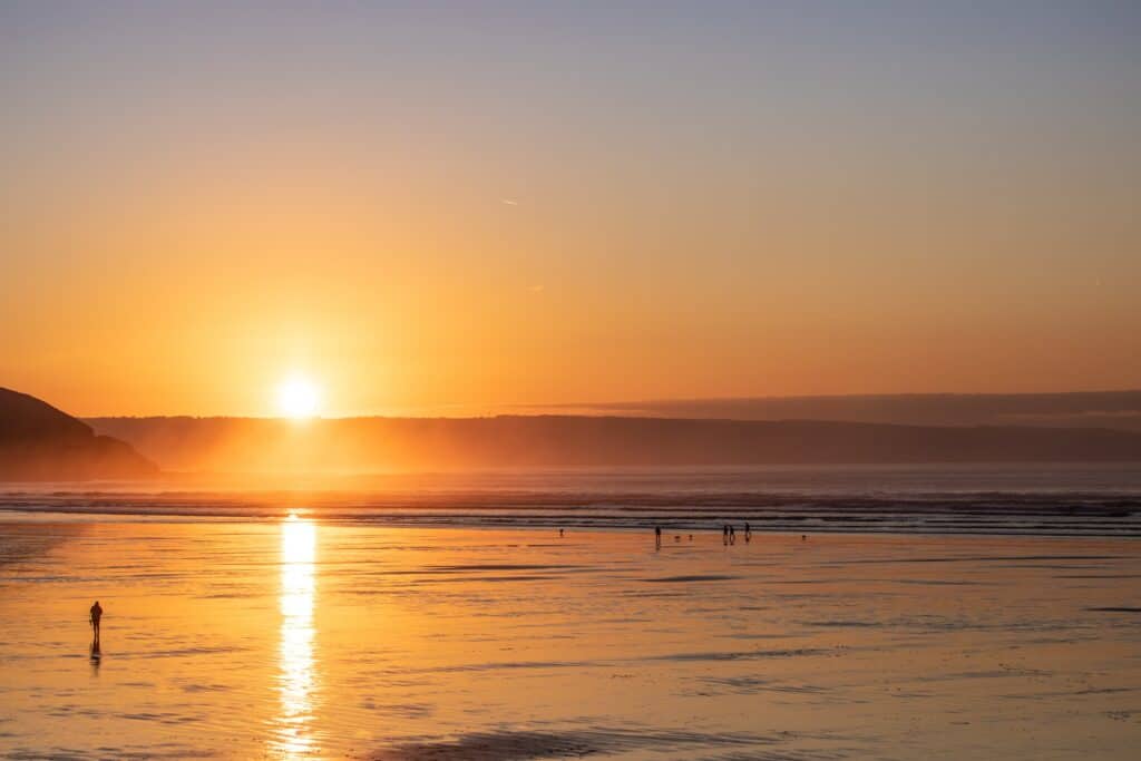 Westward Ho! Beach at sunset in winter, dog walkers in the background