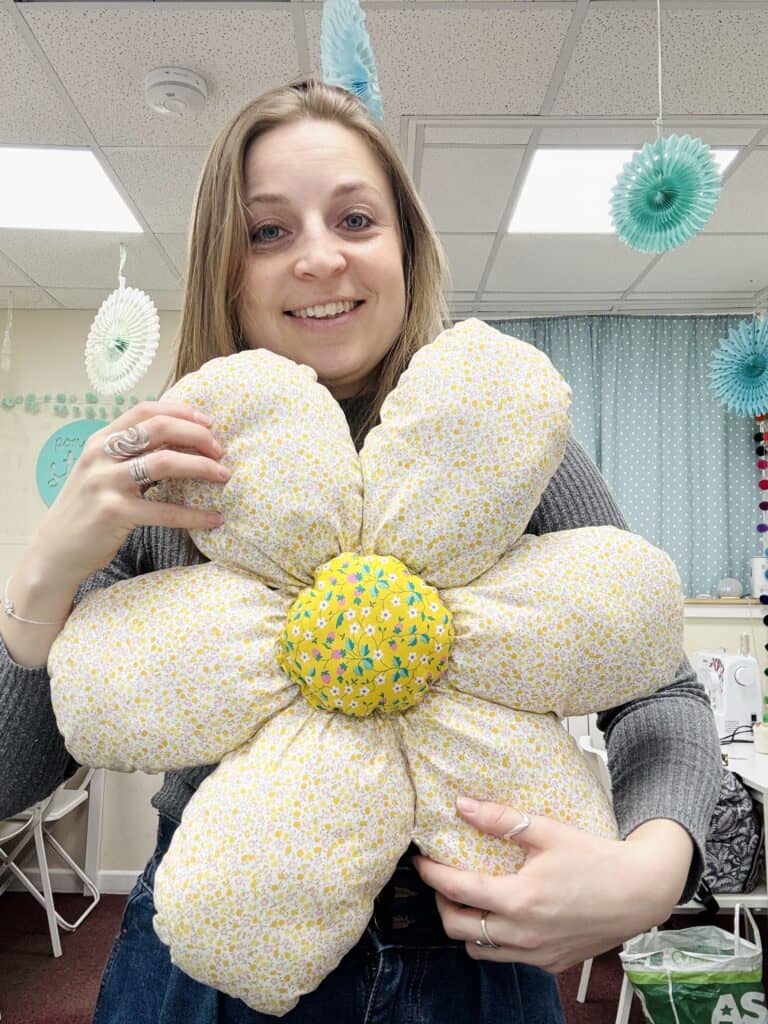 Emma holding a handmade flower cushion