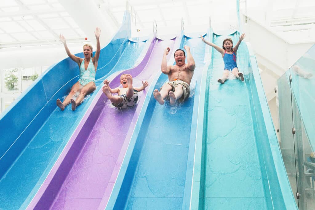 Family on indoor slide at Devon Cliffs Holiday park in Devon