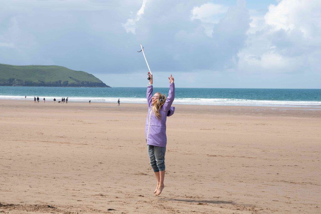 Silent disco beach clean at Woolacombe Beach, Devon. National Trust Rangers in collaboration with Plastic Free Woolacombe, are broadening the appeal of the monthly beach cleans, welcoming new audiences including many young people.